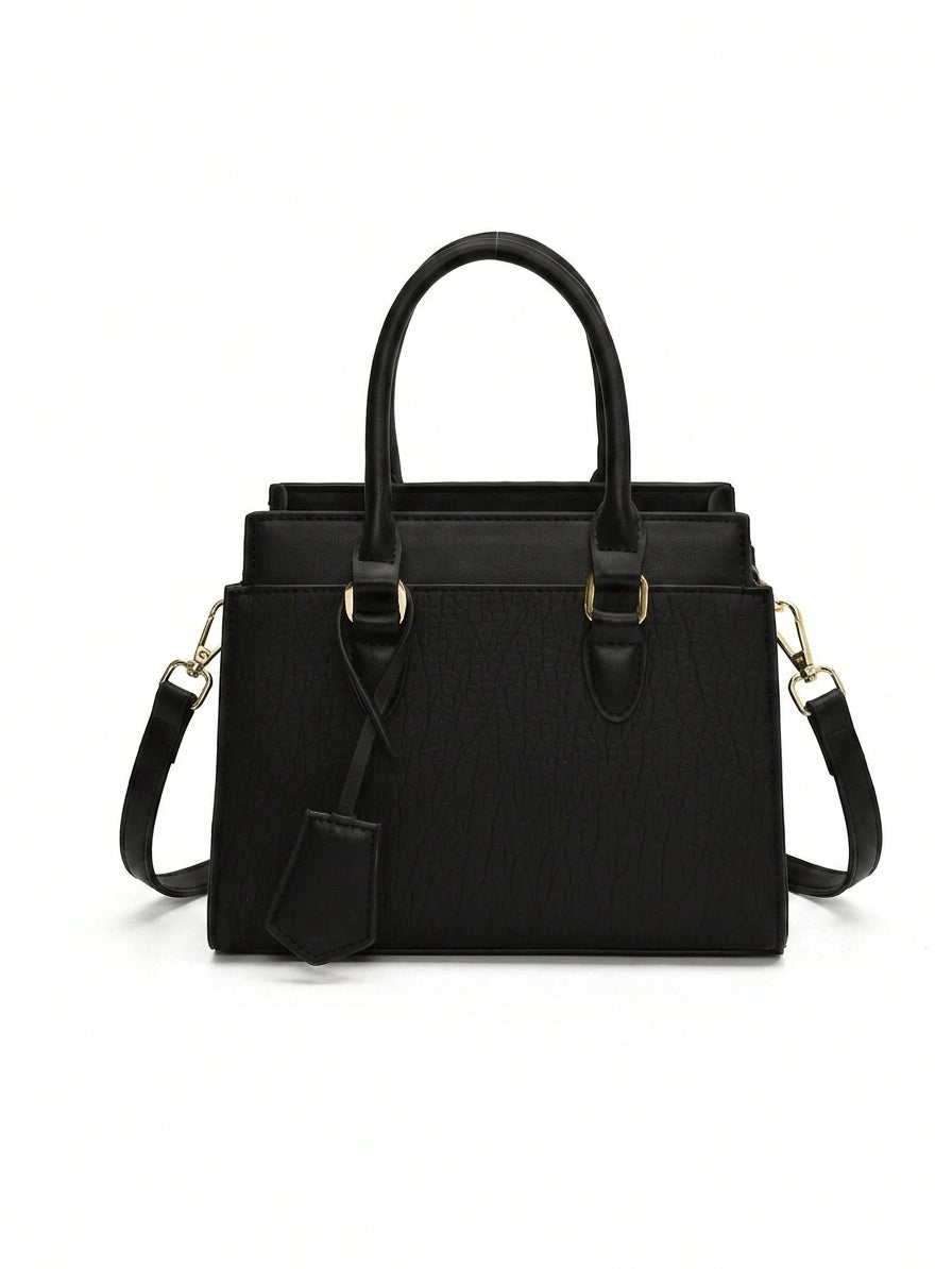 A structured black leather handbag with a subtle textured pattern, featuring dual top handles, gold-tone hardware, and a detachable shoulder strap, shown against a plain white background.