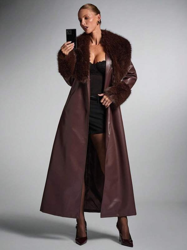 Woman wearing a long brown leather coat with fur collar against a gray background