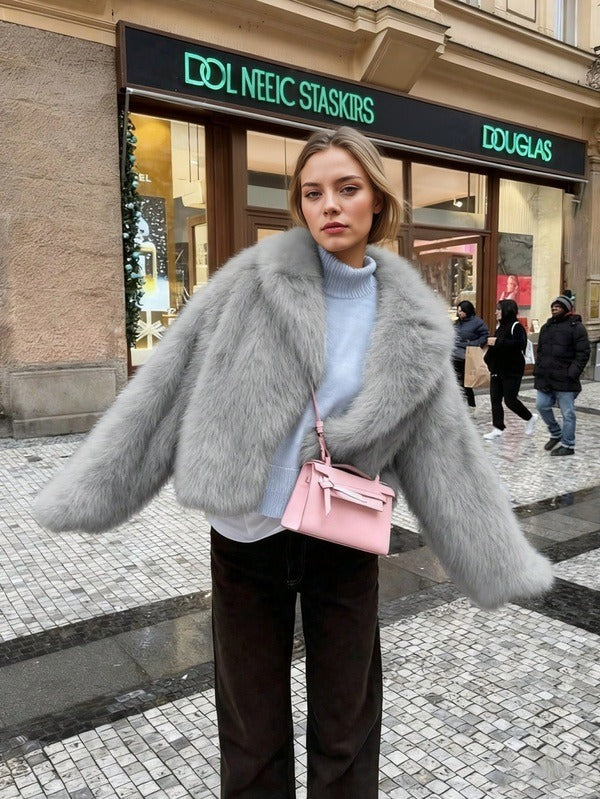 Woman in a gray fur coat with a pink bag in front of a Douglas store.